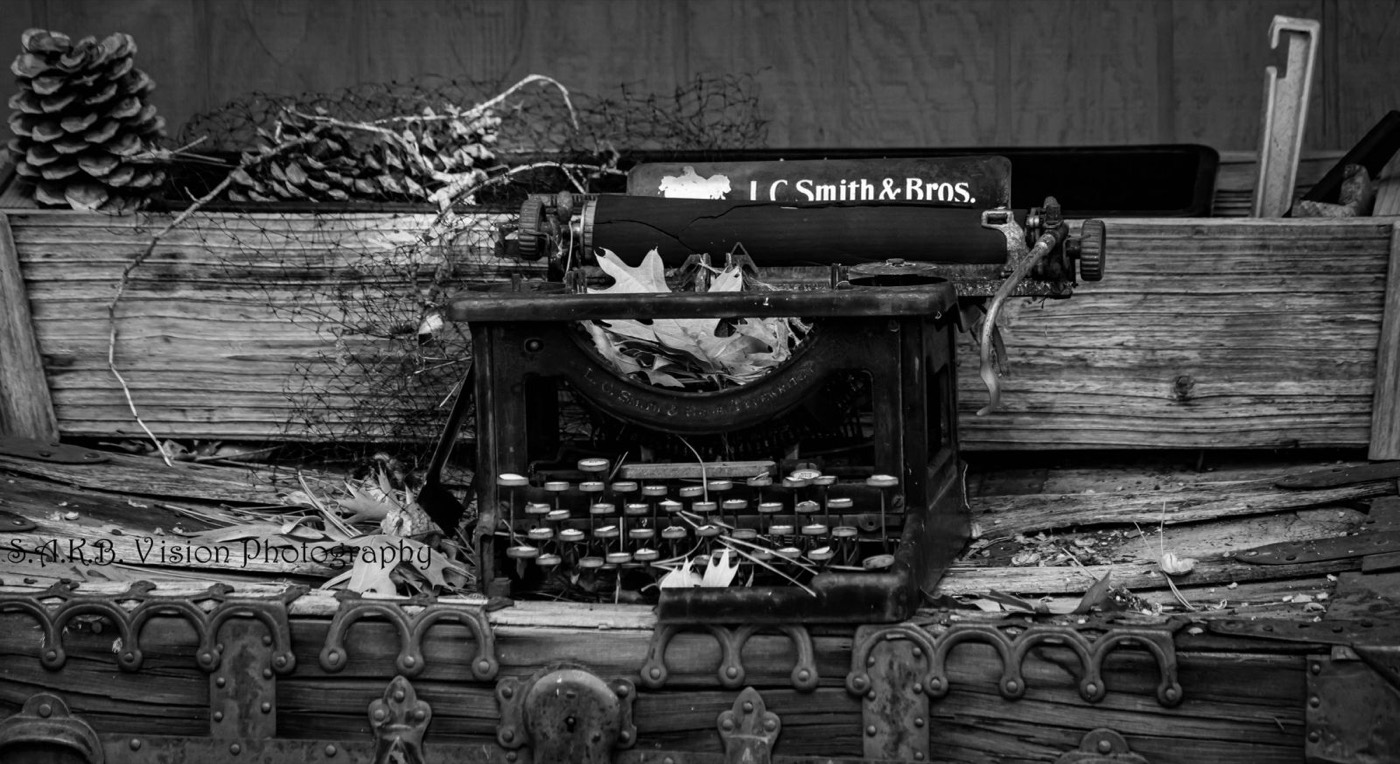 Black and white antique typewriter in a wooden crate
